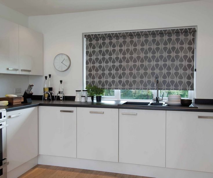 Custom made high quality patterned roller blinds by Shutter Up Brisbane, installed in a white kitchen.