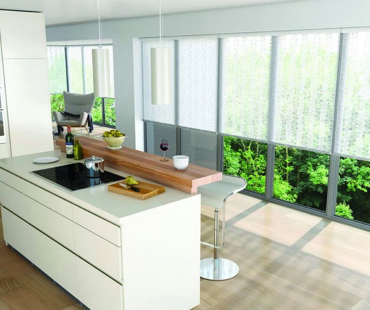 Elegant white kitchen with large windows covered with Roller/Holland Blinds. Installed by Shutter Up Brisbane.