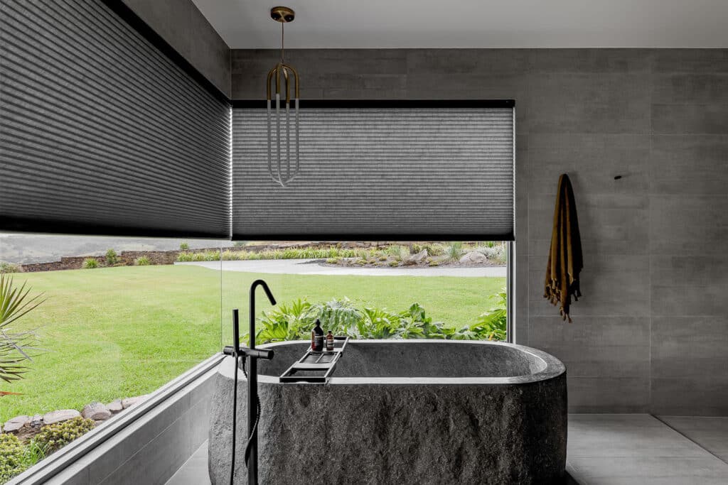 Modern elegant black stone themed bathroom featuring dark grey window blinds by Shutter Up.